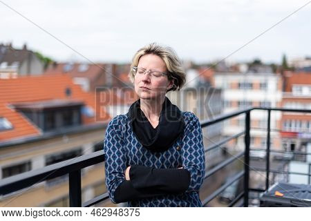 Portrait Of An Attractive Thirty Year Old Woman Posing On A Terrace, Eyes Closed, Brussels, Belgium