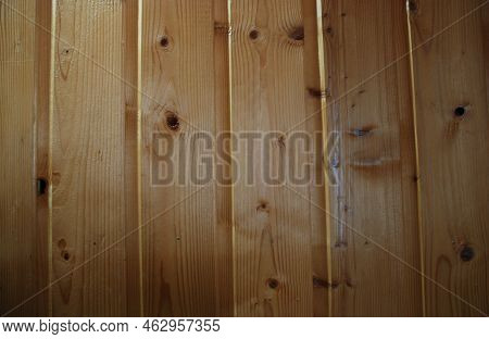 Part Of A Wooden Wall Made Of Lining. Several Planks Are Nailed To The Wall Vertically Next To Each 