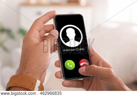Man Declining Incoming Call From Unknown Caller Indoors, Closeup. Be Careful - Fraud