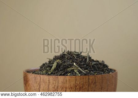 Black Dry Tea Pouring In A Bowl. Pile Of Mix Black And Green Tea Leaves. Close Up, Macro. Front View