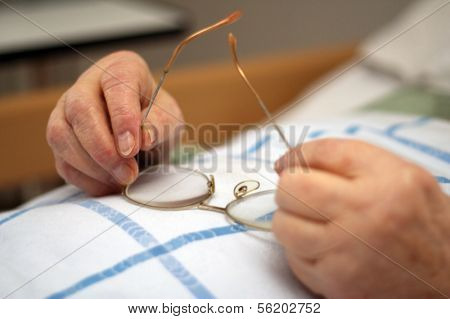 Hands of a care-dependent person holding glasses
