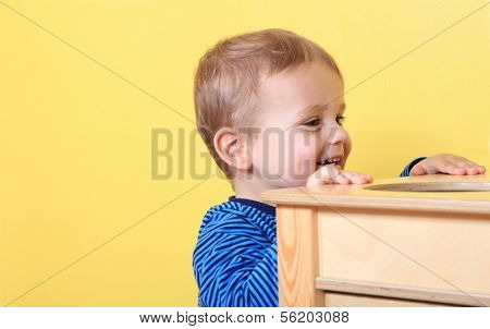 Cute european toddler having fun in kindergarten. Extra text space on left side.