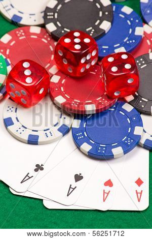 Poker Chips, Dice And Four Aces On The Green Table