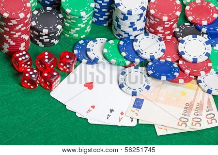Dice, Four Aces, Colorful Poker Chips And Money On A Green Felt