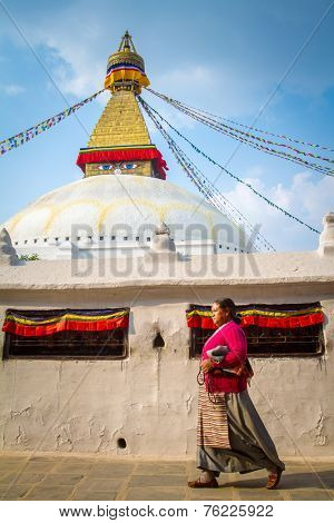 KATHMANDU, NEPAL - APRIL 1, 2013: Nepalese woman walking around Boudhanath stupa on April 1, 2013 in Kathmandu. Boudhanath stupa is the center of Buddhism pilgrimage in Nepal.