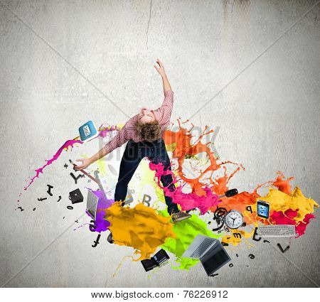Young guy in casual evading from colorful splashes