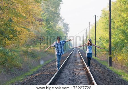 Teen Girl And Boy Balancing On Rails