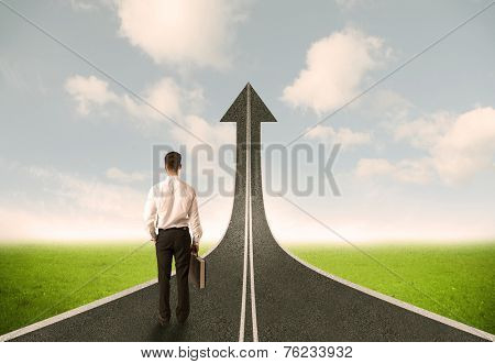 Businessman looking at 3d road upgoing arrow concept