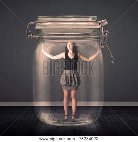 Businesswoman trapped into a glass jar concept on background