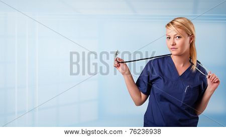 Pretty young nurse in hospital listening to empty copy space with sthetoscope