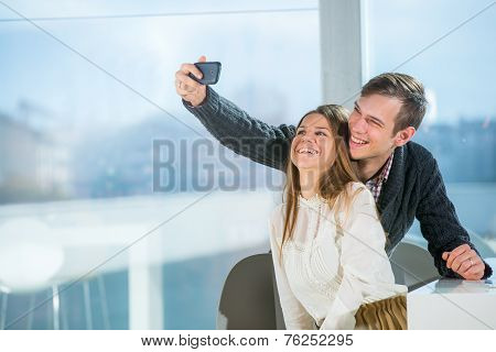 Beautiful couple taking selfie photo in cafe, selective focus