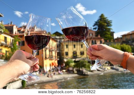 Two wineglasses in the hands. Varenna town at the lake Como, Italy 