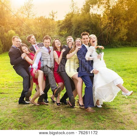 Newlyweds with guest posing in park