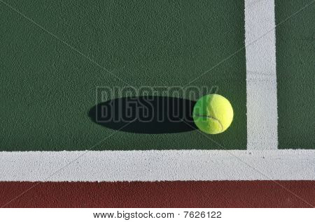 Pelota de tenis amarilla en cancha
