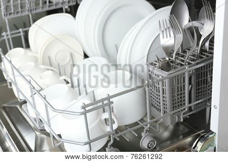 Open dishwasher with clean utensils in it