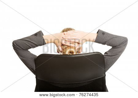 Businesswoman resting on armchair holding her neck