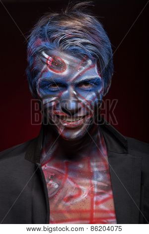 A creepy portrait of a halloween man with face art.