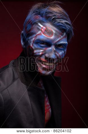 A creepy portrait of a halloween man with face art.