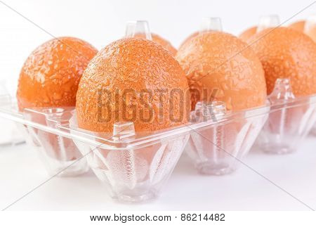 Chill Brown Egg With Water Drops In Plastic Package On White Background.