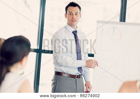 Businessman doing a presentaion in front of his collegues