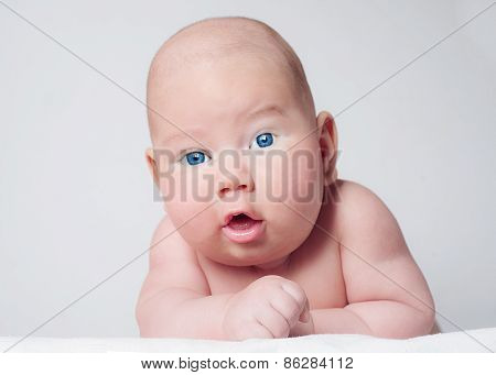 Surprised blue-eyed baby boy looking to camera