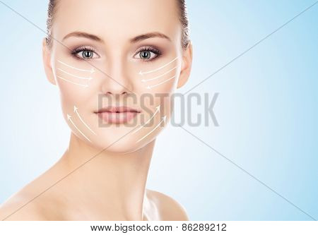 Close-up portrait of young, beautiful and healthy woman with arrows on her face. 