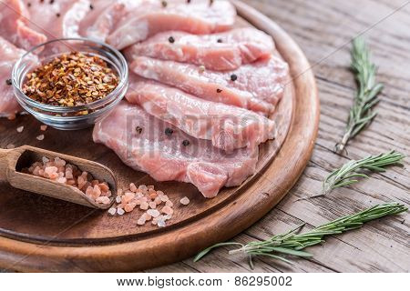 Raw Pork Steaks On The Wooden Board
