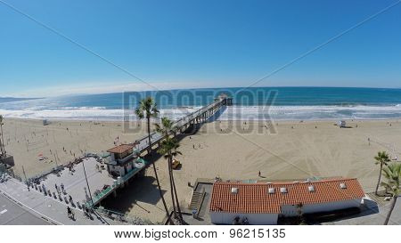 MANHATTAN BEACH - NOV 02, 2014: People walk by sandy beach and Manhattan Beach Pier at autumn sunny day. Aerial view. Pier was built in 1920.