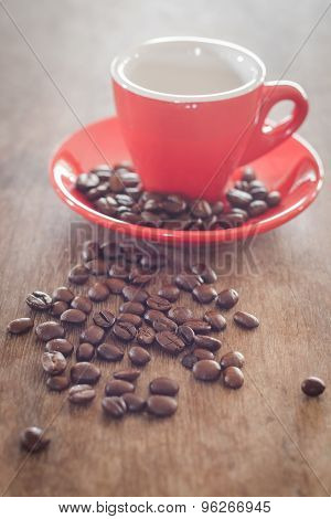 Red Coffee Cup With Coffee Beans On Wooden Table