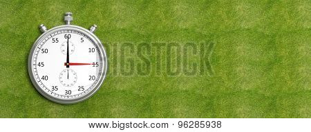 Silver chronometer on green grass