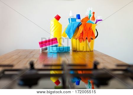 Basket With Cleaning Items On Blurry Background White Citchen. Cleaning Concept.