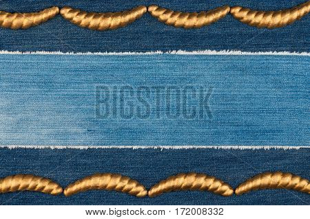Luxury elegant frame made of gold stucco plaster lying on denim. Copy space. View from above