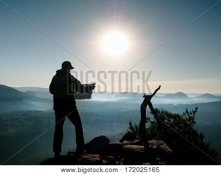 Silhouette Of Young Tourist Guide Looking In Paper  Map