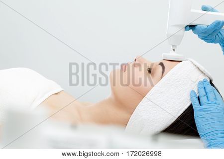 Brushing, brush-peeling. Brossage. Nozzle polishing stone. Model with closed eyes, profile, close-up. Cosmetological clinic procedures Healthcare clinic cosmetology