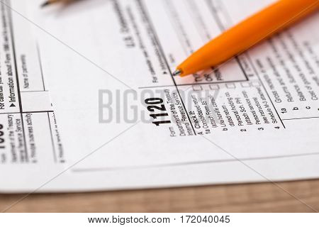US 1120 tax form with pen close up