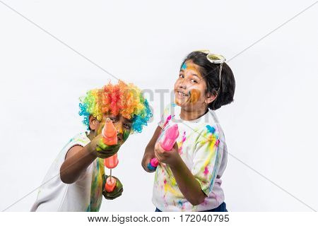 indian siblings playing colours, kids celebrating holi with gulal and pichkari, isolated over white