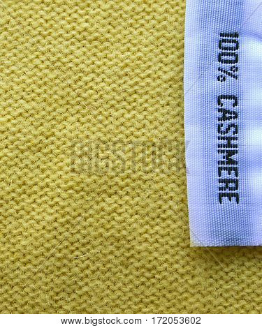 Cashmere texture.Cashmere background.100% Cashmere wool texture.Fabric label on yellow cashmere background.