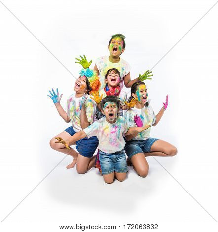 5 indian kids /friends /siblings celebrating Holi festival with and hands painted with gulal having copy space, isolated over white background