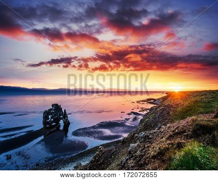 Hvitserkur is a spectacular rock in the sea on the Northern coast of Iceland. Legends say it is a petrified troll. On this photo Hvitserkur reflects in the sea water after the midnight sunset.
