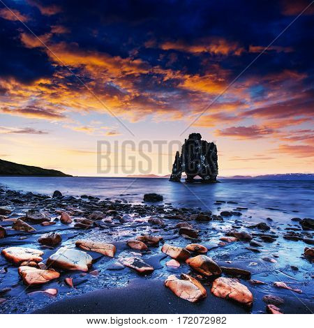 Hvitserkur is a spectacular rock in the sea on the Northern coast of Iceland. Legends say it is a petrified troll. On this photo Hvitserkur reflects in the sea water after the midnight sunset.