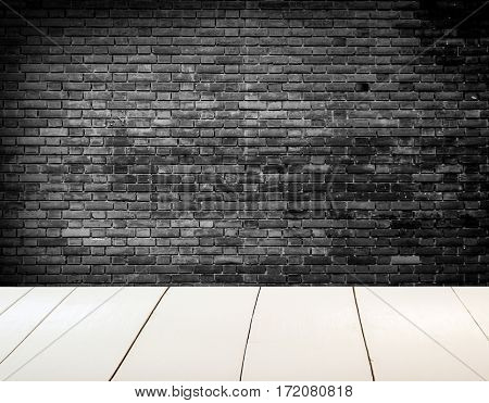 Grungy blac and white textured brick wall with white wooden floor inside