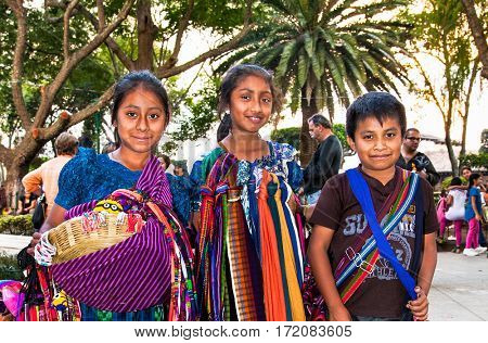 ANTIGUA, GUATEMALA-DEC 26, 2015: : Guatamalian children selling traditional  colorful fabric and goods at the street in Antigua, on Dec 26, 2015, Guatemala.