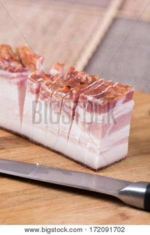 Piece Of Bacon With Kitchen Knife On The Wooden Board