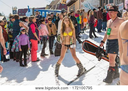 Group Of Young Happy Pretty Women On A Snowboard In Colorful Bikini With Flags.