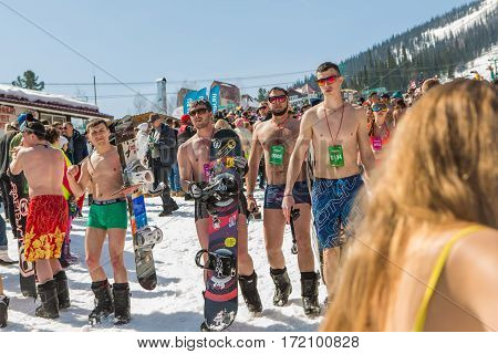 Group Of Young Happy Pretty Women On A Snowboard In Colorful Bikini With Flags.
