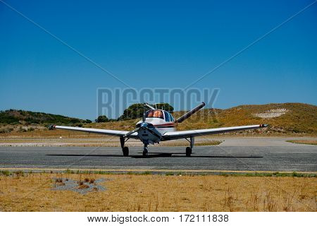 A low-wing aircarft parking in a small airport