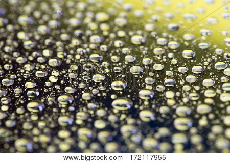Abstract black-yellow background with gradient color water drops on glass with reflection, bockeh, macro
