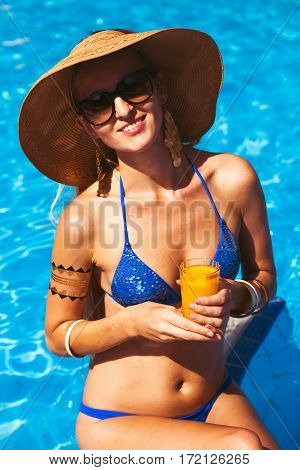 Beautiful Blonde Woman Wearing A Hat And Sunglasses, Enjoying The Pool