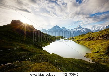 Panorama of the Bernese range in sunlight. Popular tourist attraction. Dramatic and picturesque scene. Location place Bachalpsee in Swiss alps, Grindelwald, Europe. Discover the world of beauty.