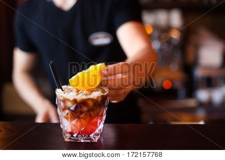 Barman Is Decorating Cocktail With Slise Orange At Night Club. Concept About Service And Beverages.